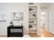 Hallway featuring modern desk area, built-in shelving, and access to updated bathroom at 1910 E Palm Ave # 10301, Tampa, FL 33605