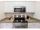 Close-up of kitchen featuring stainless steel appliances, granite countertops, and white cabinetry at 1910 E Palm Ave # 10301, Tampa, FL 33605