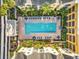 Aerial view of a large outdoor swimming pool surrounded by palm trees and lounge chairs, perfect for relaxing at 1910 E Palm Ave # 10301, Tampa, FL 33605