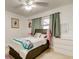 Bedroom with a ceiling fan, window, and a dresser with a picture hanging above it at 211 S Obrien St, Tampa, FL 33609