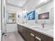 Bathroom features dual sink vanity with modern fixtures and coastal artwork at 2603 W Parkland Blvd, Tampa, FL 33609