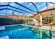 Gorgeous screened pool with blue lounge chairs at 2607 Hawks Landing Blvd, Palm Harbor, FL 34685