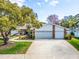 A well-maintained single-Gathering home with a large tree, lush green lawn, and a two-car garage at 2893 Turtle Ter, Palm Harbor, FL 34683