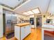 Bright kitchen with wood floors, white cabinetry, stainless steel refrigerator, and central island at 2893 Turtle Ter, Palm Harbor, FL 34683