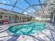 Backyard pool with a screened lanai, patio furniture, and lush landscaping at 2893 Turtle Ter, Palm Harbor, FL 34683