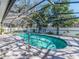 Sparkling pool surrounded by a screened enclosure and paver deck at 2893 Turtle Ter, Palm Harbor, FL 34683