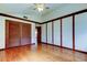 Spacious room featuring hardwood floors, wood paneling, and a ceiling fan at 2901 Pelham Rd N, St Petersburg, FL 33710