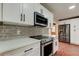 Modern kitchen features sleek appliances, white cabinetry, and stylish gray backsplash at 2901 Pelham Rd N, St Petersburg, FL 33710