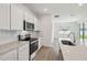 Stylish kitchen showcasing white cabinets, stainless steel appliances, and a quartz countertop with backsplash at 3980 Big Sky Dr, Spring Hill, FL 34604