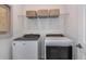 Laundry room showcasing new front-load washer and dryer, with overhead storage and a clean, functional design at 3980 Big Sky Dr, Spring Hill, FL 34604