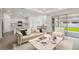 Open-concept living room featuring a modern kitchen, dining area, and large sliding doors to the backyard at 3980 Big Sky Dr, Spring Hill, FL 34604