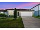 Charming single-story home with well-manicured lawn and two car garage at dusk at 4219 Big Sky Dr, Spring Hill, FL 34604