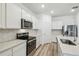 Bright kitchen featuring stainless appliances, white cabinets, hexagon backsplash, and quartz counters at 4219 Big Sky Dr, Spring Hill, FL 34604