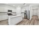Modern kitchen with stainless steel appliances, white cabinets, and a kitchen island with quartz countertops at 4219 Big Sky Dr, Spring Hill, FL 34604
