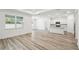 Open living area with wood-look flooring, a kitchen island, and abundant natural light at 4219 Big Sky Dr, Spring Hill, FL 34604