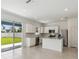 Open kitchen featuring stainless appliances, white cabinets, an eat-in island and sliding glass doors to the backyard at 4227 Big Sky Dr, Spring Hill, FL 34604