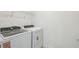 Bright laundry room with washer, dryer, and storage shelf at 4227 Big Sky Dr, Spring Hill, FL 34604