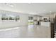 Open living space with tile floors leading to the kitchen featuring stainless steel appliances and white cabinets at 4227 Big Sky Dr, Spring Hill, FL 34604