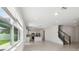 Open concept living space with tile floors next to kitchen with a stairway to the second floor at 4227 Big Sky Dr, Spring Hill, FL 34604