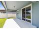 Covered patio with sliding glass door to backyard and white fence at 4227 Big Sky Dr, Spring Hill, FL 34604