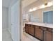 Bathroom boasts a double vanity with wood cabinets and a large mirror at 438 Seneca Falls Dr, Apollo Beach, FL 33572
