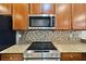 A close-up shows stainless steel microwave above glass cooktop with tile backsplash and granite countertop at 438 Seneca Falls Dr, Apollo Beach, FL 33572