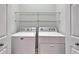 Convenient laundry room featuring modern washer, dryer, and ample storage space with shelving at 438 Seneca Falls Dr, Apollo Beach, FL 33572