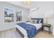 Bright bedroom featuring a queen bed, hardwood floors, two windows, and stylish decor at 4541 2Nd N Ave, St Petersburg, FL 33713