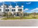 Modern townhome exterior with trellises on the roof, black trim, a black metal fence and green grass at 6207 64Th N Way, Pinellas Park, FL 33781