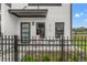 A close-up of a modern townhome with a covered patio area with black metal fence and chairs at 6207 64Th N Way, Pinellas Park, FL 33781