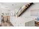 Open-concept living space showcasing modern design elements, including a large kitchen island and floating staircase at 6207 64Th N Way, Pinellas Park, FL 33781