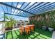 Rooftop patio with artificial turf, pergola, dining table, and faux flower wall at 6207 64Th N Way, Pinellas Park, FL 33781