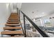 Modern staircase with wood treads, metal railings, and view into the kitchen with island seating at 6207 64Th N Way, Pinellas Park, FL 33781