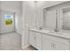 Bathroom with dual sinks, a large mirror, and natural light coming from the window at 6224 Timberdale Ave, Wesley Chapel, FL 33545