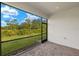 Screened patio offers peaceful outdoor living space with brick flooring and expansive views of lush greenery at 6224 Timberdale Ave, Wesley Chapel, FL 33545