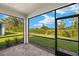 Enclosed patio provides serene views of the landscaped backyard and blue skies at 6224 Timberdale Ave, Wesley Chapel, FL 33545