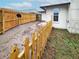 View of a fenced back yard with grass, dirt, a satellite dish, and a building with a window at 6718 Ranchwood Loop, New Port Richey, FL 34653