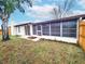 Backyard featuring a screened patio, wood fence, and tree at 6718 Ranchwood Loop, New Port Richey, FL 34653