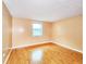 Comfortable bedroom showcases hardwood floors, neutral paint, and a large window at 6718 Ranchwood Loop, New Port Richey, FL 34653