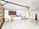 Large garage with tile flooring, featuring a work bench and overhead door at 6718 Ranchwood Loop, New Port Richey, FL 34653
