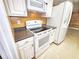 Modern kitchen with white appliances, gray countertops, and lots of cabinet space at 6718 Ranchwood Loop, New Port Richey, FL 34653