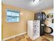 Laundry room featuring dark gray washer and dryer, built-in basket storage, and a window at 6718 Ranchwood Loop, New Port Richey, FL 34653