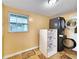 Spacious laundry room with modern washer and dryer, storage, natural light, and stylish tile floors at 6718 Ranchwood Loop, New Port Richey, FL 34653
