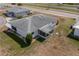 An aerial shot of the home displaying the roof, screen patio, green yard, and minimal landscaping at 702 W Brockton Pl # 2, Sun City Center, FL 33573