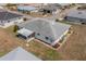 An aerial view of the property showing its roof, screened in patio, surrounding yard, and landscaping at 702 W Brockton Pl # 2, Sun City Center, FL 33573