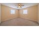 Comfortable bedroom with plush carpeting, two windows, and a ceiling fan at 702 W Brockton Pl # 2, Sun City Center, FL 33573