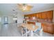 Kitchen with eat-in dining includes wood cabinets, ceiling fan, and tiled floor at 702 W Brockton Pl # 2, Sun City Center, FL 33573