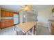 Eat-in kitchen shows dining table, wooden cabinets, ceiling fan, and tiled floor at 702 W Brockton Pl # 2, Sun City Center, FL 33573