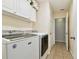 Bright laundry room with overhead cabinets and washer and dryer at 10115 Whisper Pointe Dr, Tampa, FL 33647