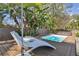 Relaxing backyard pool with deck, loungers, umbrella, and privacy fencing surrounded by lush landscaping at 1013 E North St, Tampa, FL 33604